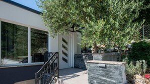 A modern building with a stone facade, a metal staircase, and a large tree in front. - Soothing Holiday Home in Starigrad near Sea (Starigrad)