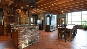 A rustic interior with a stone fireplace, wooden beams, and a dining area. - Renovated Mill in Bastogne Near Waterfall (Bastogne)