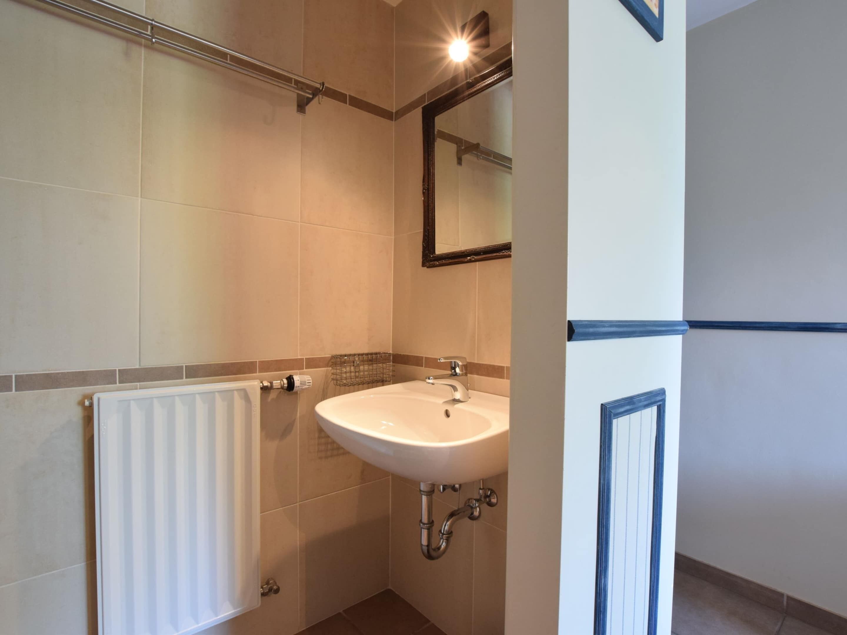 A bathroom with a white sink, a towel rack, and a mirror.