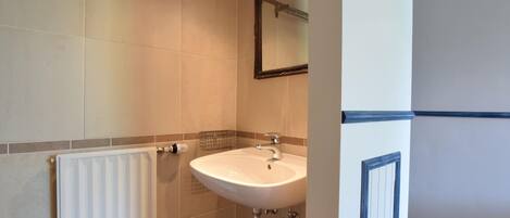 A bathroom with a white sink, a towel rack, and a mirror.