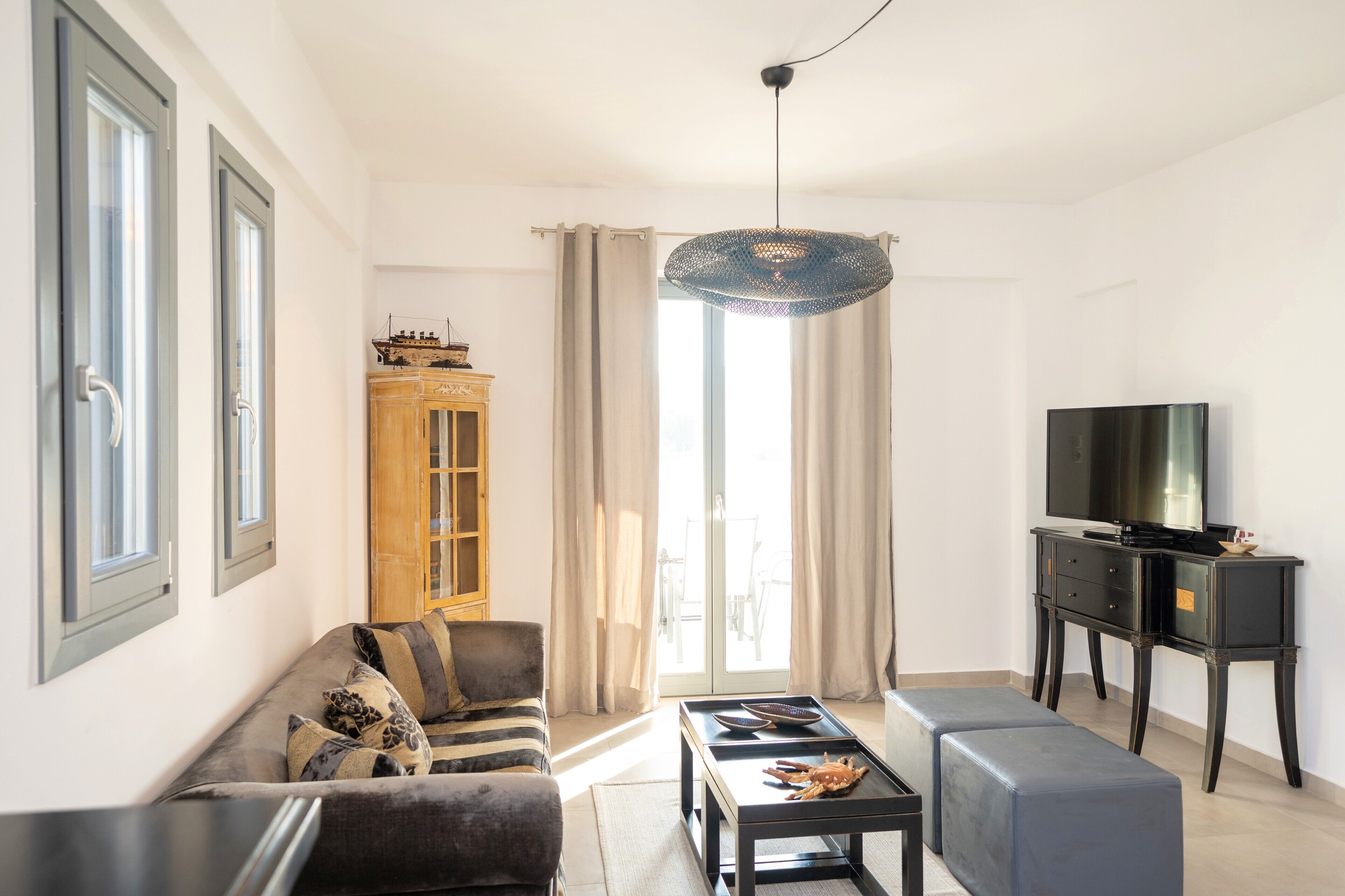 Een moderne woonkamer met een bank, een salontafel, een tv-meubel en een kast.