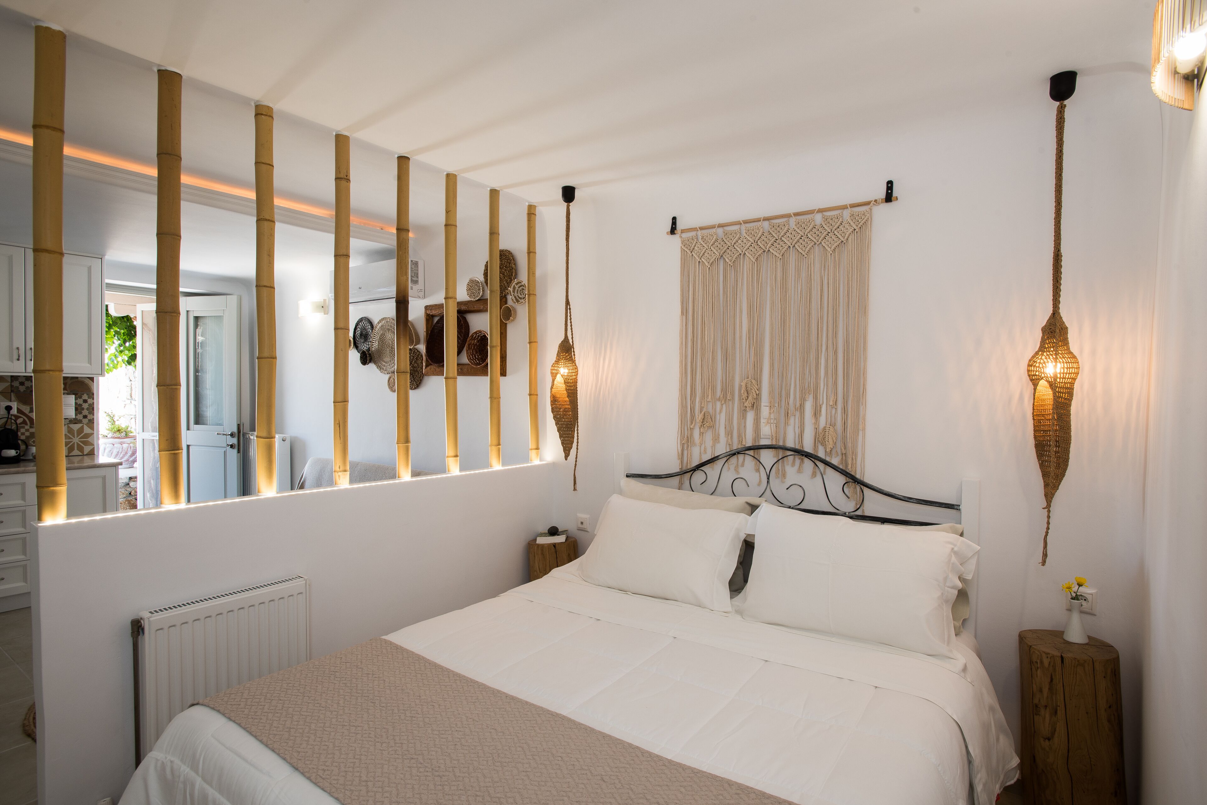 Een keurig opgemaakt slaapkamer met een groot bed, nachtkastjes, een spiegel en wandlampen.