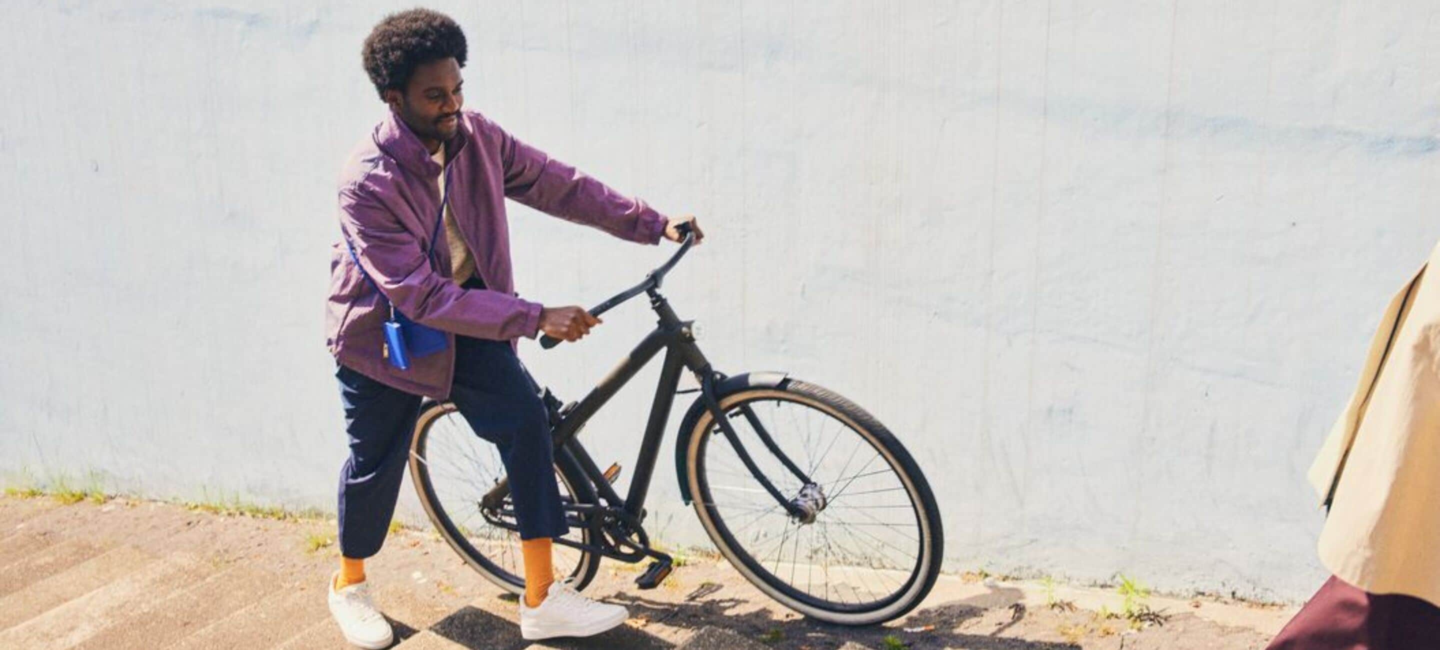 Una persona in bicicletta di fronte a un muro liscio.