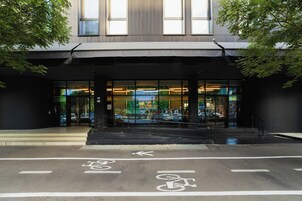 A building entrance with a bike lane, glass doors, and a staircase leading to the entrance.
