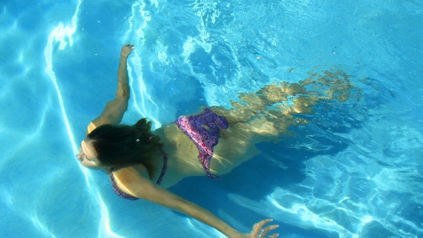 Une personne qui nage dans une piscine.
