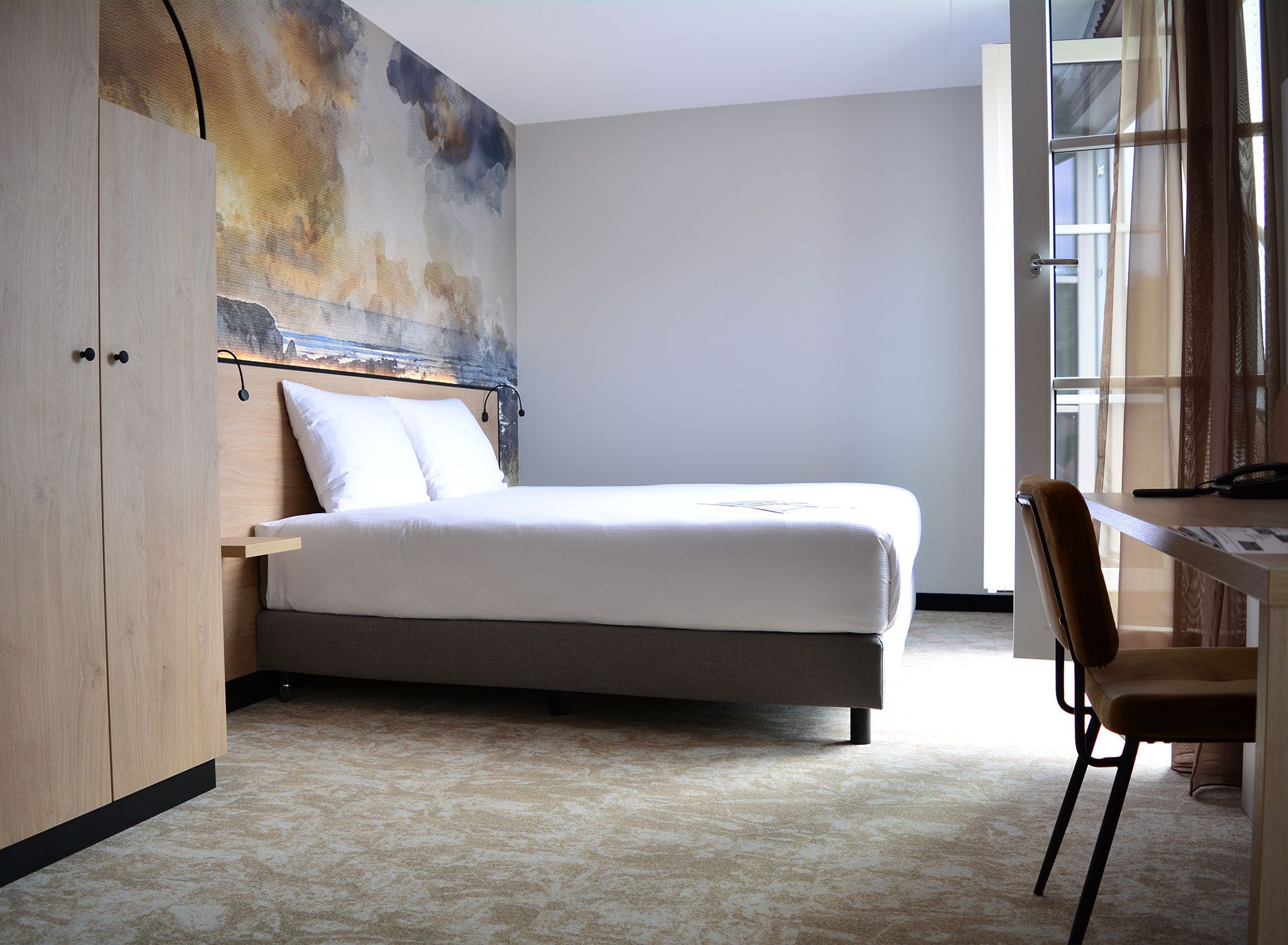 A bedroom with a bed, a desk, and a chair.