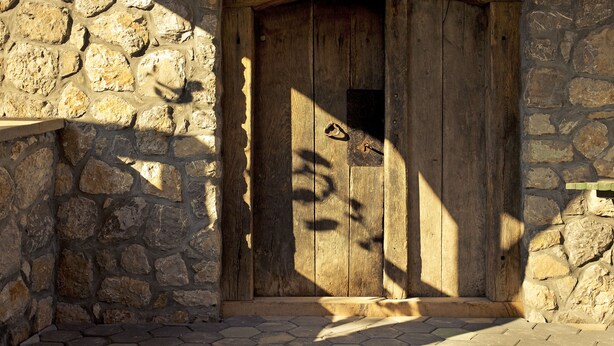 Una pared de piedra rústica con una puerta de madera.