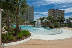 A hotel pool area with a central water feature, surrounded by palm trees and a clear sky. - BEAUTIFUL BEACHFRONT! SPACIOUS COASTAL RETREAT! 1 MILE E OF PIER PARK!BCH SRVC INCL!!! (Panama City Beach)