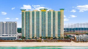 Un grand hôtel avec de nombreux balcons, situé près d’une plage.