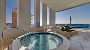 A hot tub with a view of the ocean, surrounded by lounge chairs and a pool. - BEAUTIFUL BEACHFRONT! 1 MILE W OF PIER PARK! (Panama City Beach)