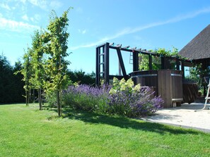 Eine Gartenlaube aus Holz mit Lavendelpflanzen.