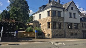 A two-story stone building with a white upper section and a stone lower section. - Waimes Wellness & Nature Villa (Waimes)
