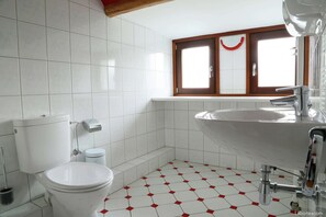 A bathroom with a toilet, sink, and window. - Waimes Wellness & Nature Villa (Waimes)