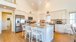 A spacious kitchen with a central island, stainless steel appliances, and a large window providing natural light. - Custom Single Family home with Expansive Bayfront views! (Wildwood Crest)