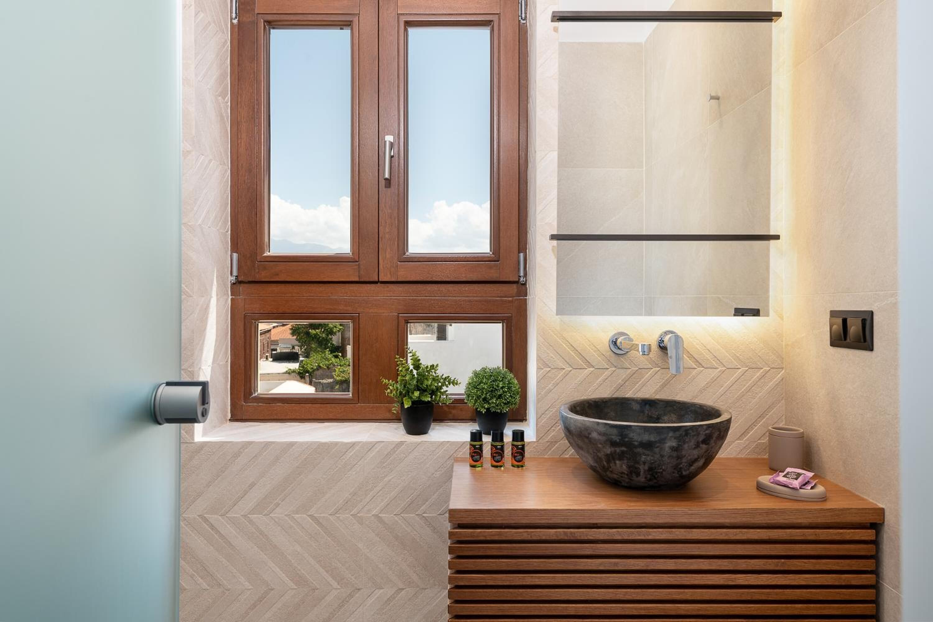 Ein modernes Badezimmer mit einem Holzbadezimmer-Möbel, einem großzügigen Waschbecken und einem Spiegel darüber.