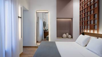 Una habitación de hotel moderna con una cama grande, una mesita de noche, un espejo y un panel de pared de madera.