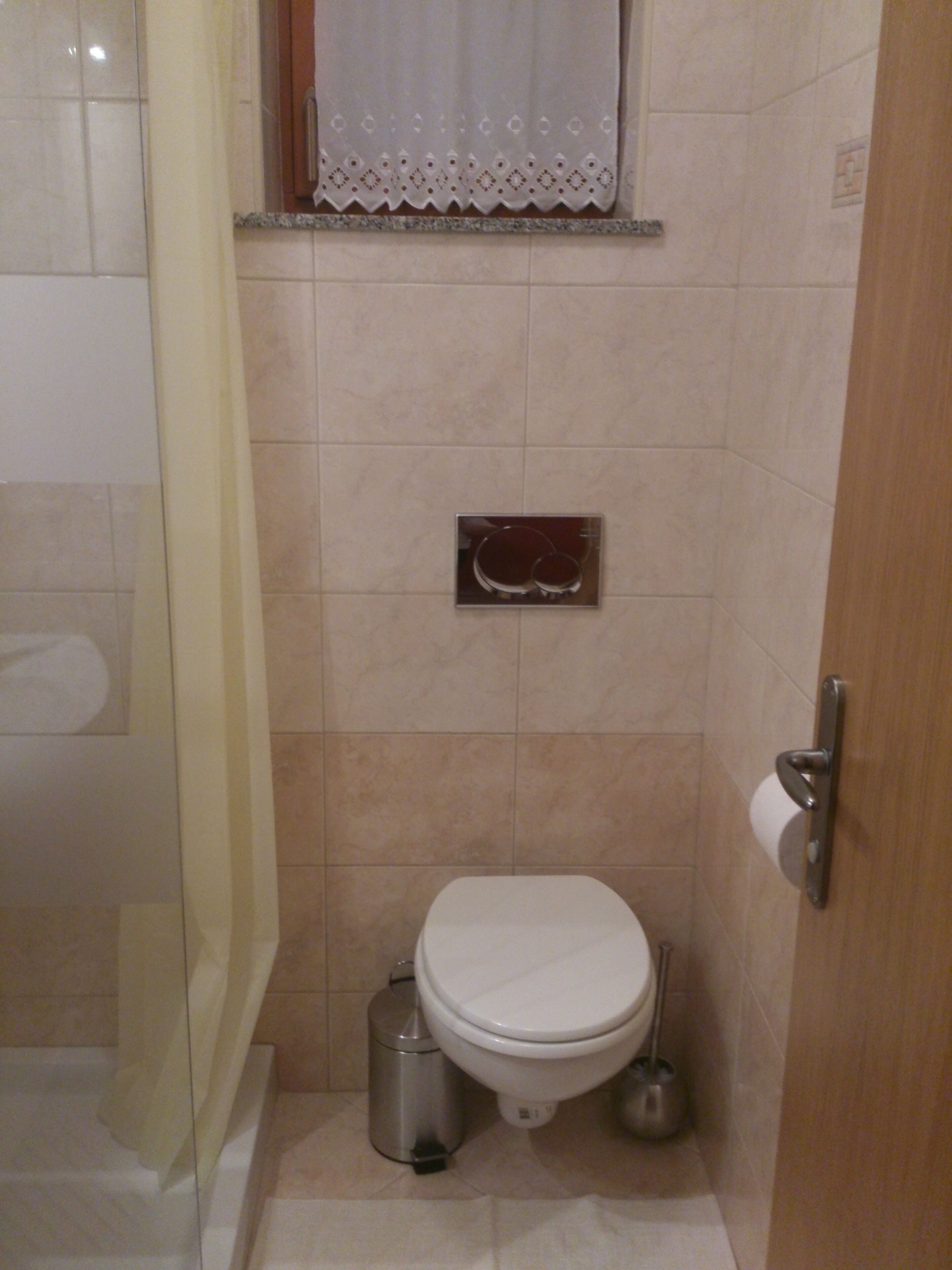 Un bagno piccolo con un water, una cestino e un bidet.