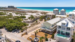 A coastal hotel with multiple buildings, a beach view, and a swimming pool.