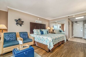 Ein Schlafzimmer mit einem Bett, zwei Sofas, einem Schreibtisch und einem Koffer.