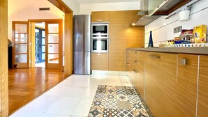 Une cuisine moderne avec des meubles en bois, des appareils électroménagers en acier inoxydable et un tapis à motifs.