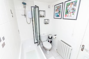 A bathroom with a toilet, shower, and a radiator. - Seaview Cottage (Dundee)