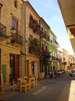 Experience the charm of a historic European town, where traditional buildings and balconies with flowering plants create a cozy atmosphere.