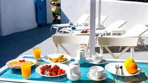 A breakfast table with plates of food, drinks, and a fruit.