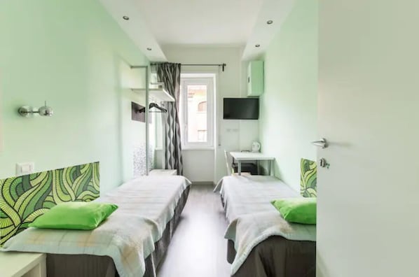 A room with two beds, a desk, a TV, and a window with curtains. - B&B di Paolo S. (Rome)