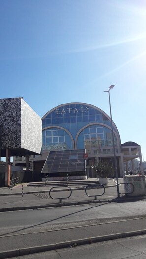 A modern building with a curved glass facade and the word 'EATALY' prominently displayed. - B&B di Paolo S. (Rome)