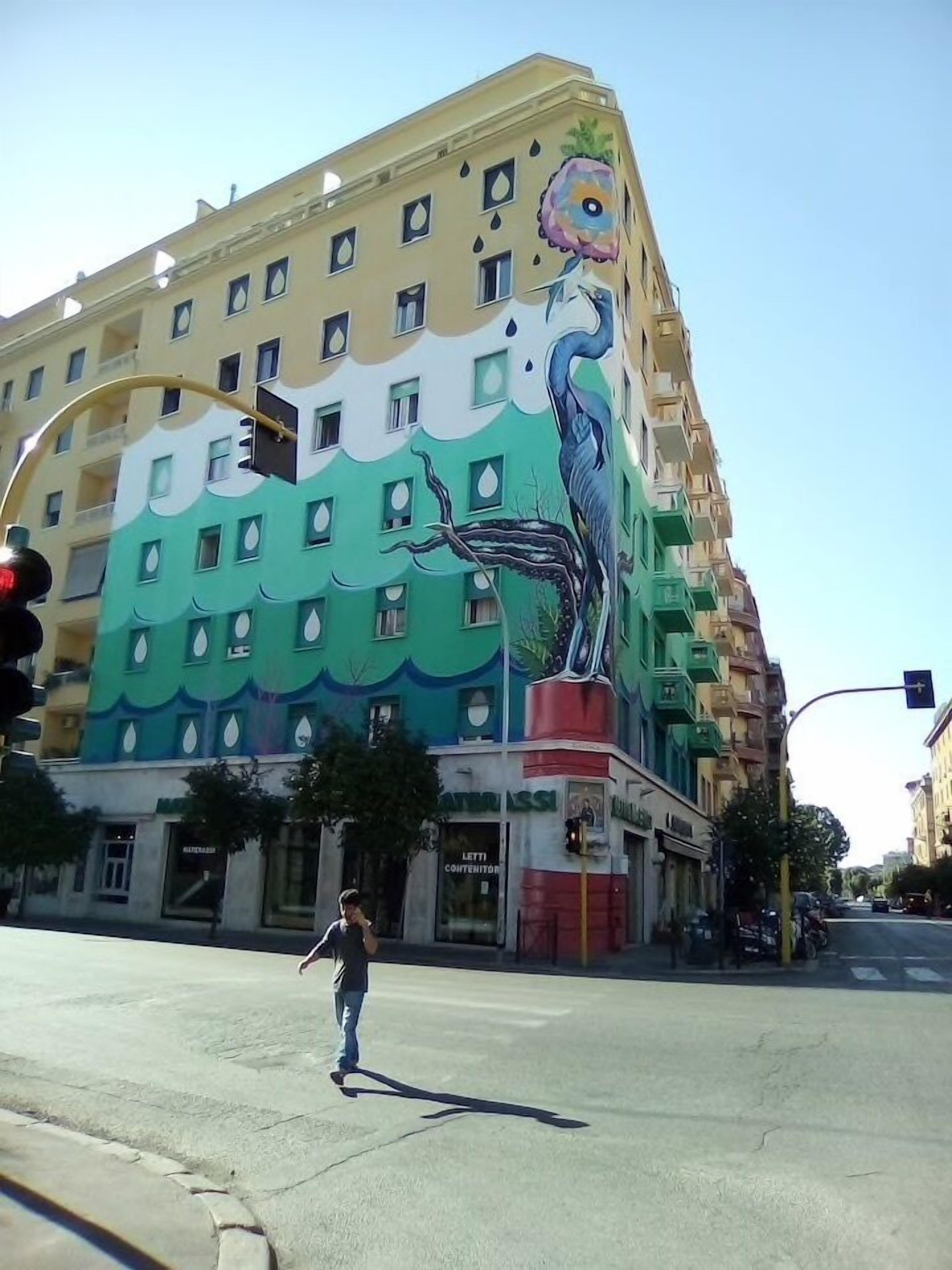Un edificio con un mural colorido que muestra un pájaro y olas.