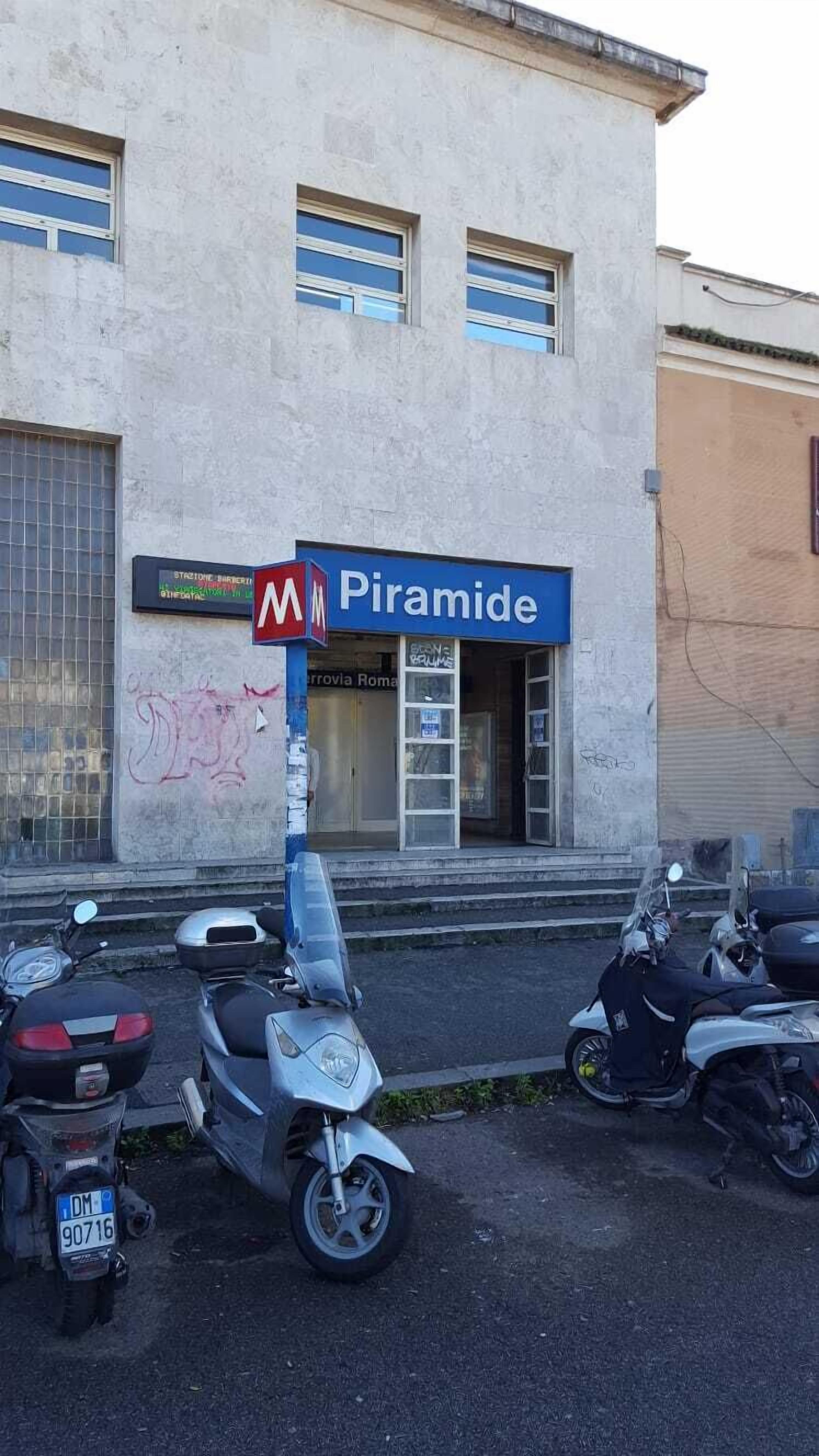 Un edificio con un cartel que dice 'Piramide' y varias motocicletas estacionadas.