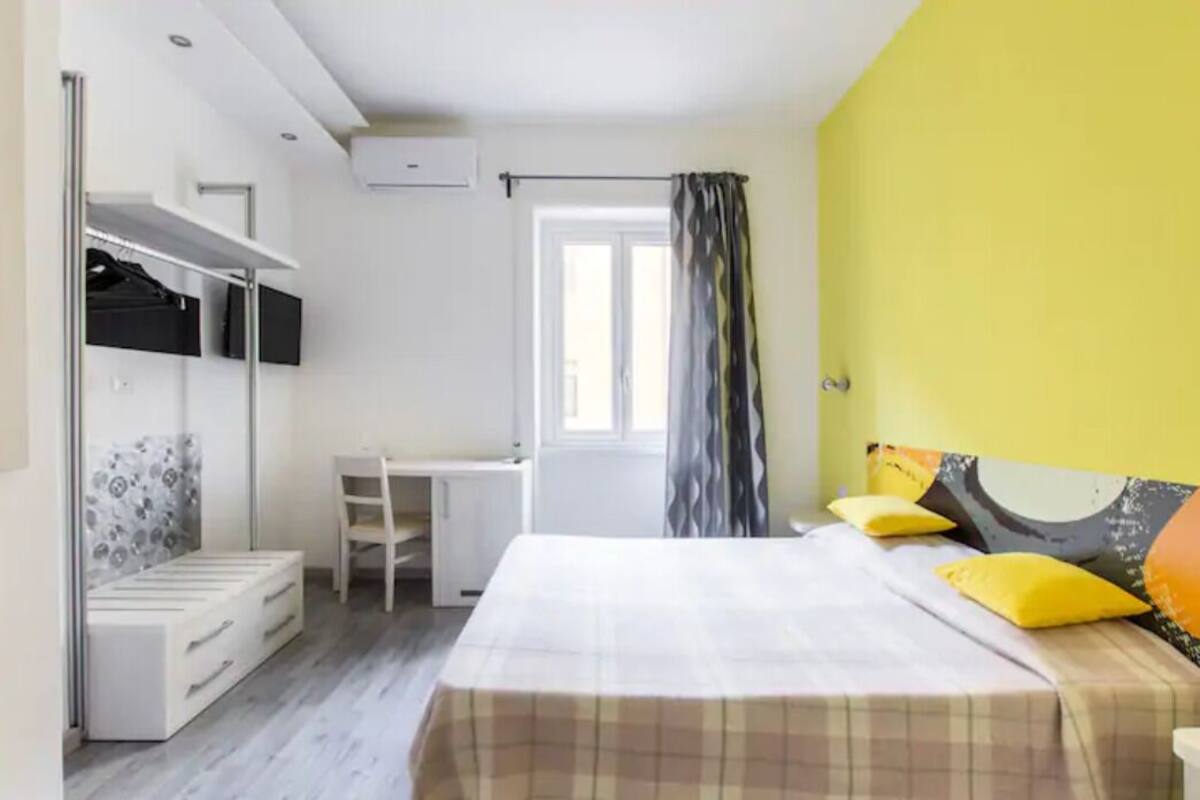 Un dormitorio con cama, escritorio y armario.
