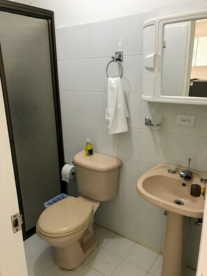 A bathroom with a toilet, sink, and a towel rack. - La Martinera Parque Central (Guatapé)