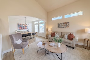A spacious living room with a sofa, armchair, coffee table, and dining area. - Mountain Home- Sleeps 16- Hot tub, Views, Pickleball, Family Friendly (Heber City)
