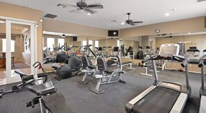 Un gimnasio con cintas de correr, elípticas y bancos de pesas.