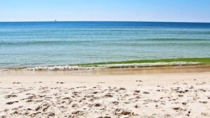 A sandy beach with footprints leading to the water. - Dream Catcher (Gulf Shores)