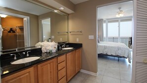 A bathroom with two sinks, a large mirror, and a walk-in closet. - Colonnades 1202 (Gulf Shores)