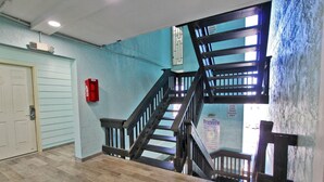 A staircase with wooden railings and a handrail, leading to an upper floor. - Beachview 203 (Gulf Shores)