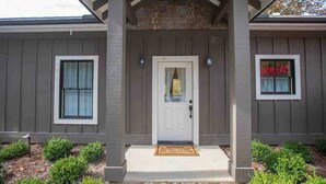 A house with a front porch, a door, and two windows.