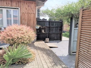 A wooden deck with a potted plant and a wooden fence. - STUDIO "house" with TERRACE at the foot of the cycle paths (Audenge)