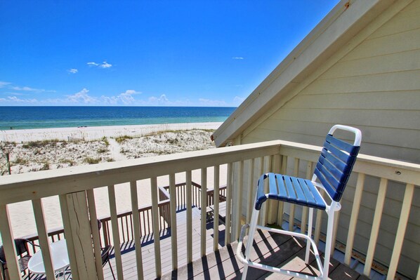 A balcony with a view of the beach and ocean.