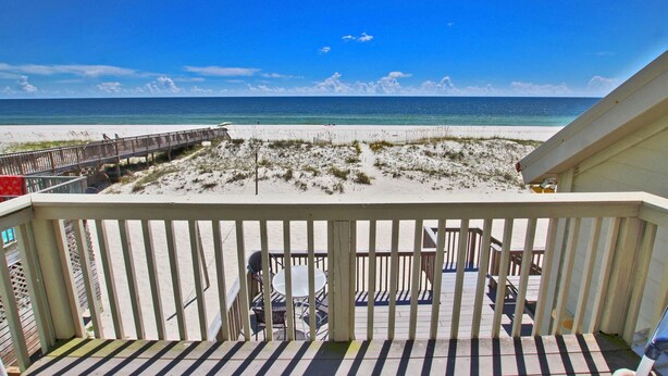 Ein Balkon mit Blick auf Strand und Meer.