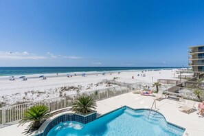 Un espace piscine offrant une vue sur la plage et l’océan.