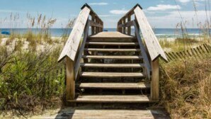 A wooden staircase leading to a beach.