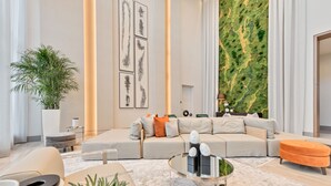 Ein modernes Wohnzimmer mit einem Ecksofa, einem Couchtisch und einer großen Küstpflanze.