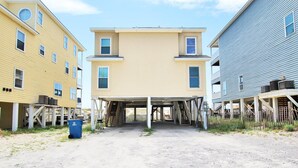 Un bâtiment à deux étages doté d’une entrée abritée et d’une allée non pavée.