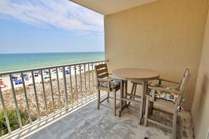 Ein Balkon mit Blick auf Strand und Meer.