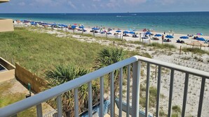A beach with numerous umbrellas and people. - Westwind 301 (Gulf Shores)