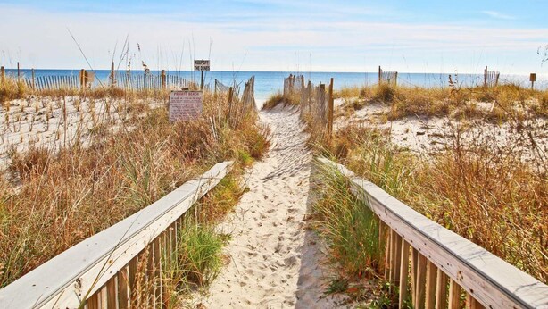 A sandy beach path with wooden railings and signs indicating private beach access. - Westwind 301 (Gulf Shores)