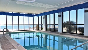 An indoor swimming pool with clear views of the beach through large windows. - Summerchase 1108 (Orange Beach)